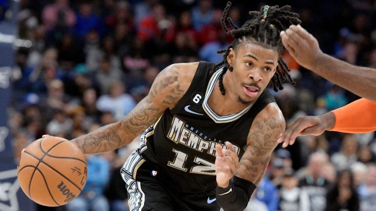 Memphis Grizzlies guard Ja Morant (12) drives against Oklahoma City Thunder forward Luguentz Dort (5) during the first half of an NBA basketball game Friday, Nov. 18, 2022, in Memphis, Tenn. (AP Photo/Brandon Dill)