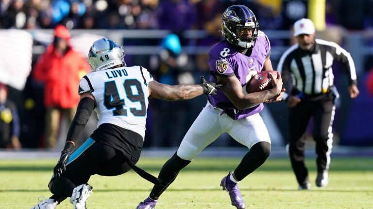 Baltimore Ravens quarterback Lamar Jackson (8) gets by Carolina Panthers linebacker Frankie Luvu (49) in the first half of an NFL football game Sunday, Nov. 20, 2022, in Baltimore. (Patrick Semansky/AP)