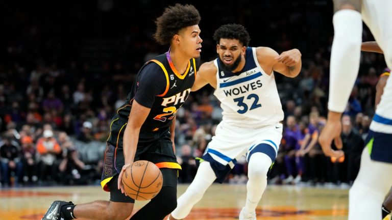 Phoenix Suns forward Cameron Johnson drives as Minnesota Timberwolves center Karl-Anthony Towns (32) defends during the second half of an NBA basketball game, Tuesday, Nov. 1, 2022, in Phoenix. (Matt York/AP)