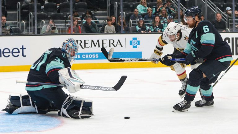 Vegas Golden Knights center Paul Cotter (43) tries to score as Seattle Kraken goaltender Philipp Grubauer and defenseman Adam Larsson defend during the third period of an NHL hockey game. (Jason Redmond/AP)