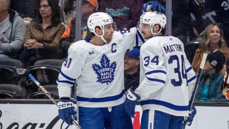 Toronto Maple Leafs center John Tavares, left, celebrates a goal by center Auston Matthews as Anaheim Ducks center Isac Lundestrom, right, skates by during the first period of an NHL hockey game in Anaheim, Calif., Sunday, Oct. 30, 2022. (AP Photo/Alex Gallardo)