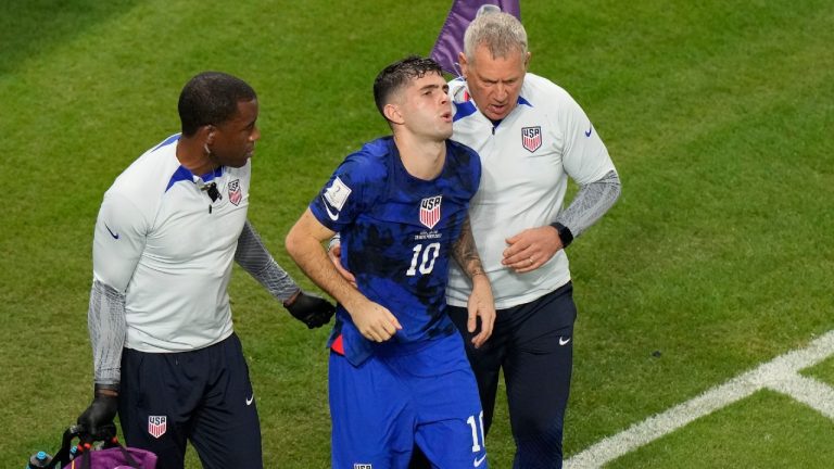 Christian Pulisic of the United States is helped by team doctors after he scoring his side's opening goal during the World Cup group B soccer match between Iran and the United States at the Al Thumama Stadium in Doha, Qatar, Tuesday, Nov. 29, 2022. (Luca Bruno/AP)