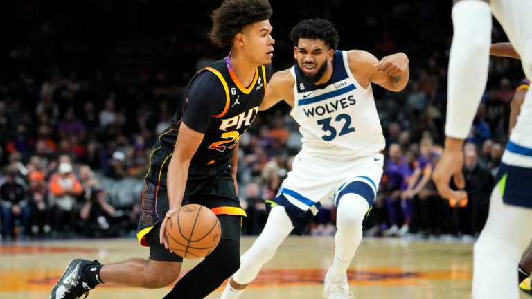 Phoenix Suns forward Cameron Johnson drives as Minnesota Timberwolves center Karl-Anthony Towns (32) defends during the second half of an NBA basketball game, Tuesday, Nov. 1, 2022, in Phoenix. (Matt York/AP)