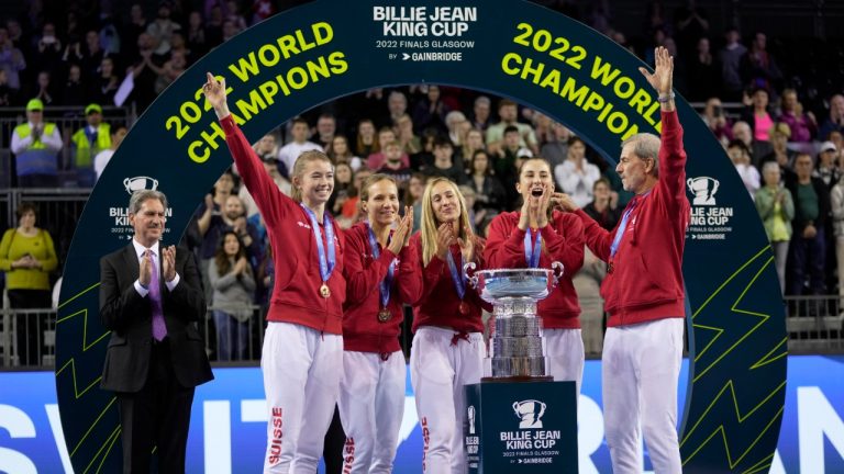 Switzerland's players Simona Waltert, Viktorija Golubic, Jil Teichmann, Belinda Bencic and Switzerland team captain Heinz Guenthardt, from left, celebrate after defeating Australia to win the Billie Jean King Cup tennis finals, at the Emirates Arena in Glasgow, Scotland, Sunday, Nov. 13, 2022. (Kin Cheung/AP)