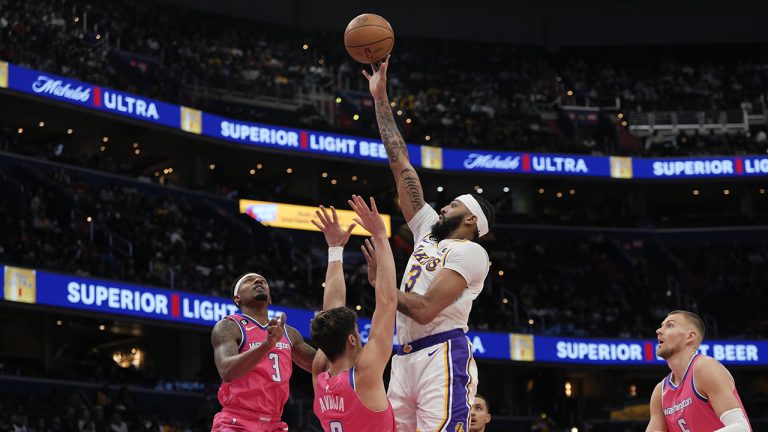 Los Angeles Lakers forward Anthony Davis, scores as Washington Wizards guard Bradley Beal, left, and forward Deni Avdija (9) defend during the first half of an NBA basketball game, Sunday, Dec. 4, 2022, in Washington. (Jess Rapfogel/AP)