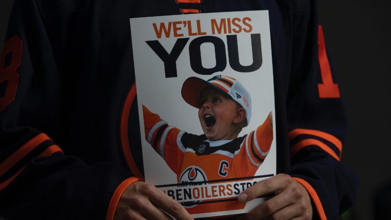 Supporters gather to show their respect for young Edmonton Oilers fan Ben Stelter, who died of cancer, as his funeral procession passes Rogers Place in Edmonton, Alberta, on Friday, Aug. 19, 2022. (Amber Bracken/CP)