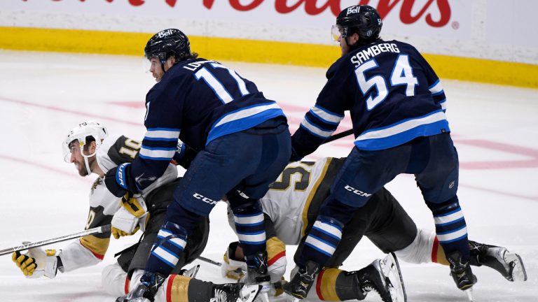 Winnipeg Jets’ Adam Lowry (17) and Dylan Samberg (54) check Vegas Golden Knights’ Nicolas Roy (10) and Keegan Kolesar (55) during third period NHL action in Winnipeg on Tuesday December 13, 2022. THE CANADIAN PRESS/Fred Greenslade