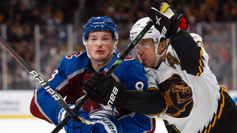 Boston Bruins defenseman Charlie McAvoy tries to hold up Colorado Avalanche's Cale Makar during the third period of an NHL hockey game Saturday, Dec. 3, 2022, in Boston. (AP)