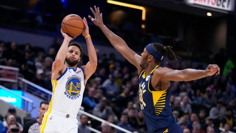 Golden State Warriors guard Stephen Curry (30) shoots over Indiana Pacers center Myles Turner (33) during the first half of an NBA basketball game in Indianapolis, Wednesday, Dec. 14, 2022. (Michael Conroy/AP)