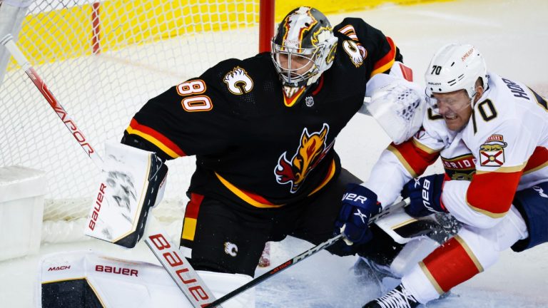 Florida Panthers forward Patric Hornqvist, right, crashes into Calgary Flames goalie Dan Vladar during second period NHL hockey action in Calgary, Tuesday, Nov. 29, 2022. (Jeff McIntosh/CP)