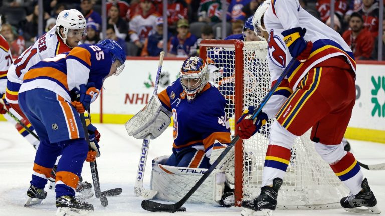 New York Islanders goaltender Semyon Varlamov makes a save against New Jersey Devils defenseman Dougie Hamilton, right, during the third period of an NHL hockey game Friday, Dec. 9, 2022, in Newark, N.J. The Islanders won 6-4. (Adam Hunger/AP)