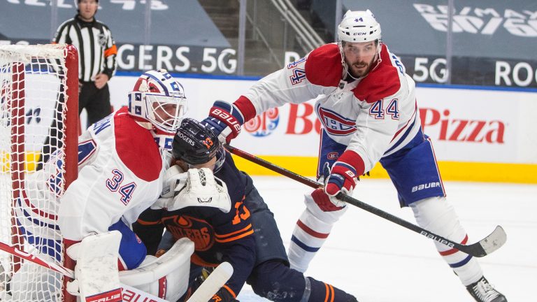 Edmonton Oilers' Jesse Puljujarvi (13) is checked into Montreal Canadiens' goalie Jake Allen (34) by Joel Edmundson (44) during second period NHL action in Edmonton, Monday, April 19, 2021. (Jason Franson/CP)