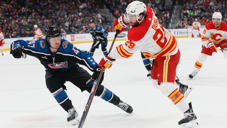 Flames Blue Jackets Hockey
Calgary Flames' Dillon Dube, front right, shoots past Columbus Blue Jackets' Marcus Bjork during the first period of an NHL hockey game on Friday, Dec. 9, 2022, in Columbus, Ohio. (Jay LaPrete/AP)