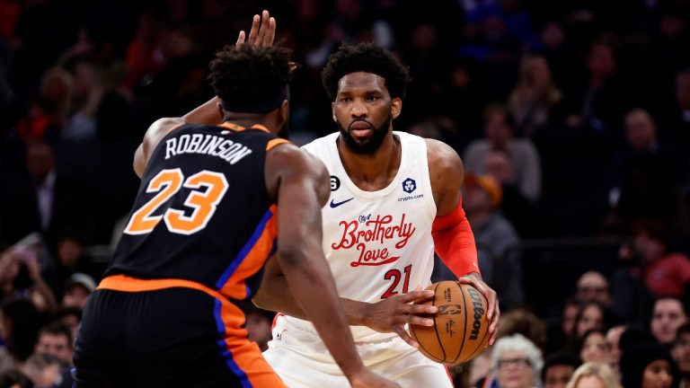 Philadelphia 76ers center Joel Embiid (21) looks to pass around New York Knicks center Mitchell Robinson during the first half of an NBA basketball game, Sunday, Dec. 25, 2022, in New York. (Adam Hunger/AP Photo)