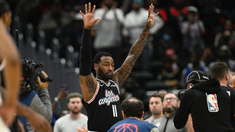 Los Angeles Clippers guard John Wall (11) raises his hands to the crowd as he is recognized on the scoreboard during a break in the action in the first half of an NBA basketball game against the Washington Wizards, Saturday, Dec. 10, 2022, in Washington. Wall is a former Wizards player. (Nick Wass/AP)