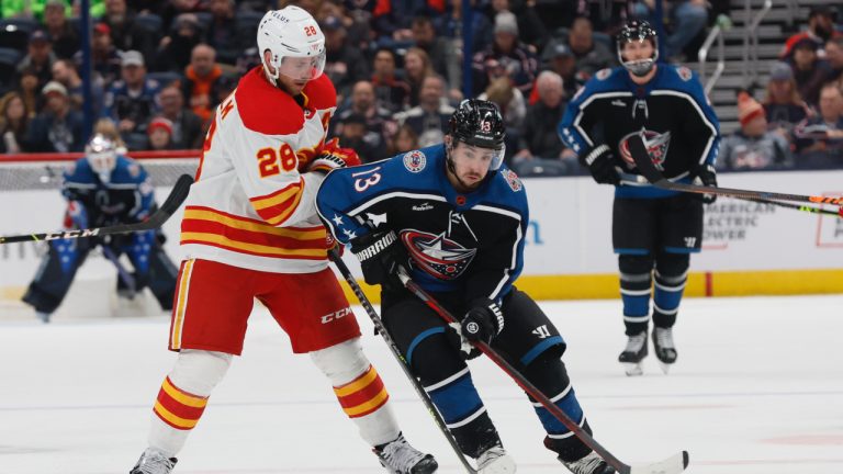 Columbus Blue Jackets' Johnny Gaudreau, right, carries the puck across the blue line past Calgary Flames' Elias Lindholm during the second period of an NHL hockey game Friday, Dec. 9, 2022, in Columbus, Ohio. (Jay LaPrete/AP)