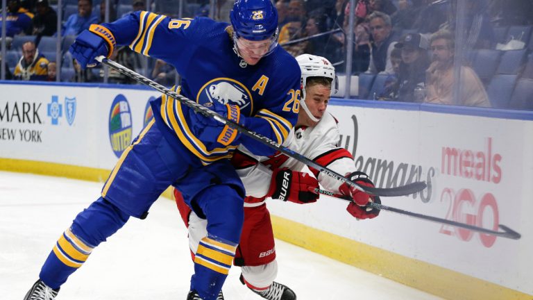 Buffalo Sabres defenseman Rasmus Dahlin (26) checks Carolina Hurricanes center Lane Pederson (18) during the first period of a preseason NHL hockey game Tuesday, Oct. 4, 2022, in Buffalo, N.Y. (Joshua Bessex/AP)