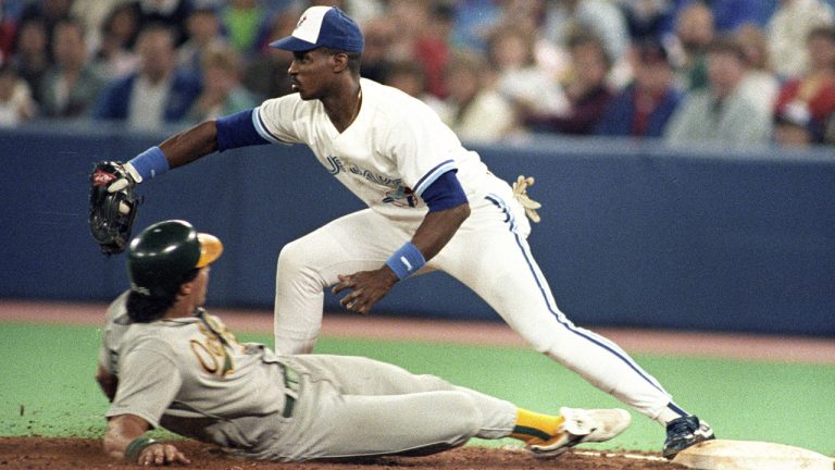 Toronto Blue Jays Fred McGriff tags Oakland's Jose Canseco out at first base, May 21, 1990. (Hans Deryk/CP)