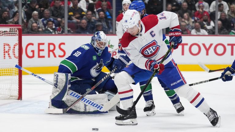 Vancouver Canucks goalie Collin Delia (60) watches as Montreal Canadiens' Nick Suzuki (14) skates with the puck during the second period of an NHL hockey game in Vancouver, B.C., Monday, Dec. 5, 2022. (Darryl Dyck/CP)