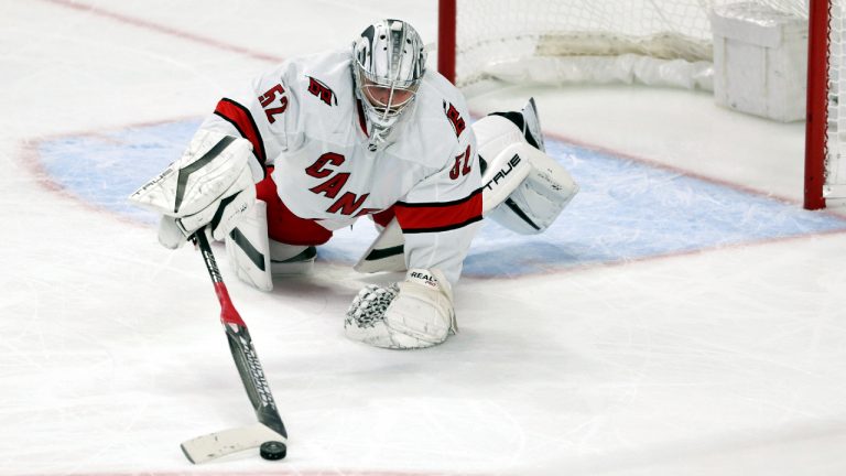 Carolina Hurricanes goaltender Pyotr Kochetkov (52) knocks the puck away from the net during the third period of a preseason NHL hockey game against the Buffalo Sabres on Tuesday, Oct. 4, 2022, in Buffalo, N.Y. (Joshua Bessex/AP)