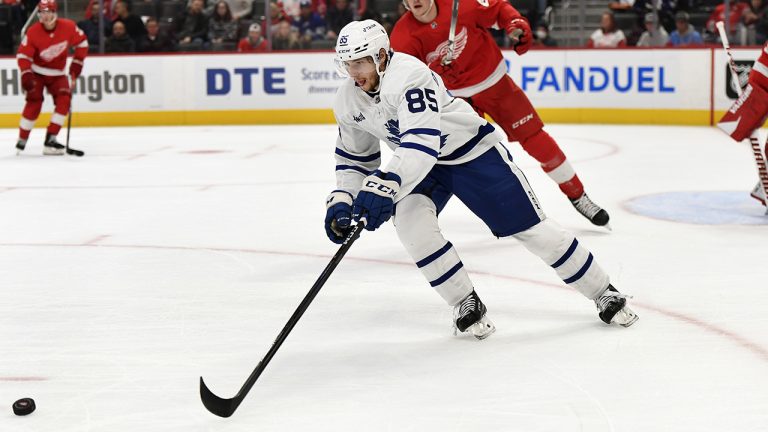 Toronto Maple Leafs center Semyon Der-Arguchintsev, front, reaches for the puck during the first period of the team's NHL preseason hockey game against the Detroit Red Wings, Friday, Oct. 7, 2022, in Detroit. (Jose Juarez/AP)