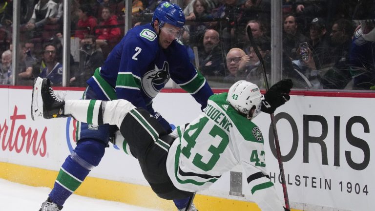 Vancouver Canucks' Luke Schenn (2) checks Dallas Stars' Marian Studenic (43), of Slovakia, during the third period of an NHL hockey game in Vancouver, B.C., Monday, April 18, 2022. (Darryl Dyck/The Canadian Press)