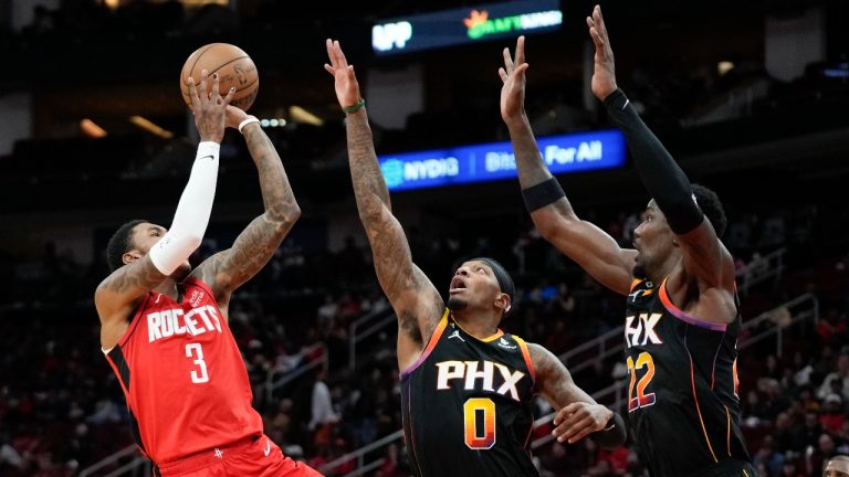 Houston Rockets guard Kevin Porter Jr. shoots as Phoenix Suns forward Torrey Craig and center Deandre Ayton defend during the first half of an NBA basketball game, Tuesday, Dec. 13, 2022, in Houston. (Eric Christian Smith/AP Photo)