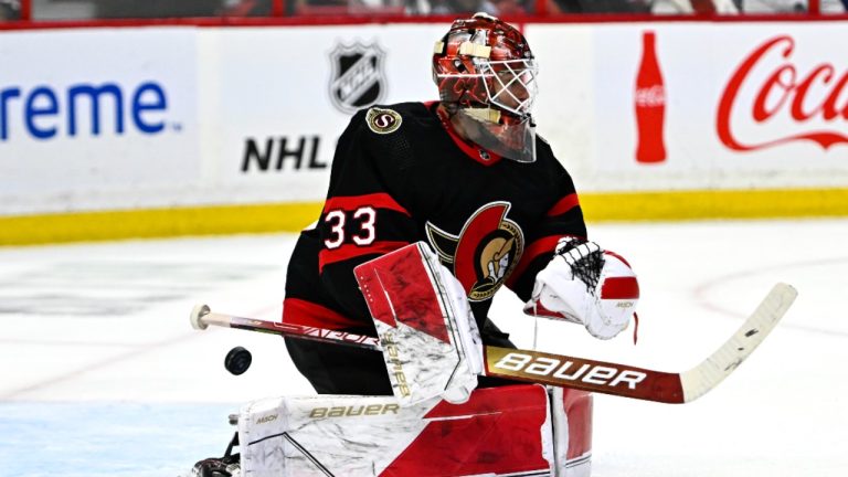 The puck goes past Ottawa Senators goaltender Cam Talbot (33). (Justin Tang/CP)