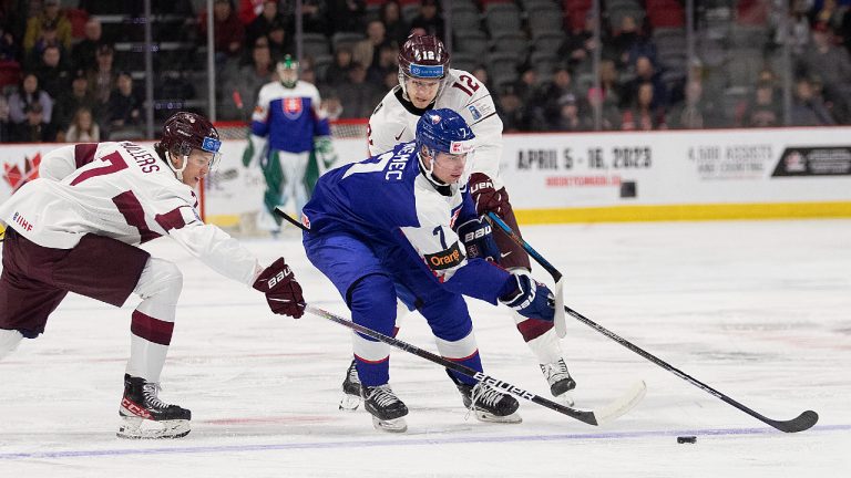 Slovakia's Simon Nemec (centre) splits Latvia's Rainers Rullers (left) and Roberts Cjunskis during first period IIHF World Junior Hockey Championship hockey action in Moncton, N.B., on Friday, Dec. 30, 2022. (Ron Ward/CP)