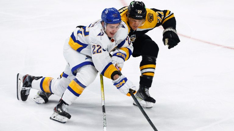 Buffalo Sabres right wing Jack Quinn (22)] is stick-checked by Boston Bruins defenseman Hampus Lindholm (27) during the third period of an NHL hockey game Saturday, Nov. 12, 2022, in Buffalo, N.Y. (Jeffrey T. Barnes/AP) 