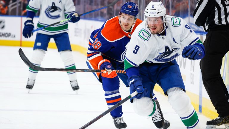 Vancouver Canucks forward J.T. Miller, right, and Edmonton Oilers forward Zach Hyman follow the play during first period NHL hockey action in Edmonton, Friday, Dec. 23, 2022.(Jeff McIntosh/CP)