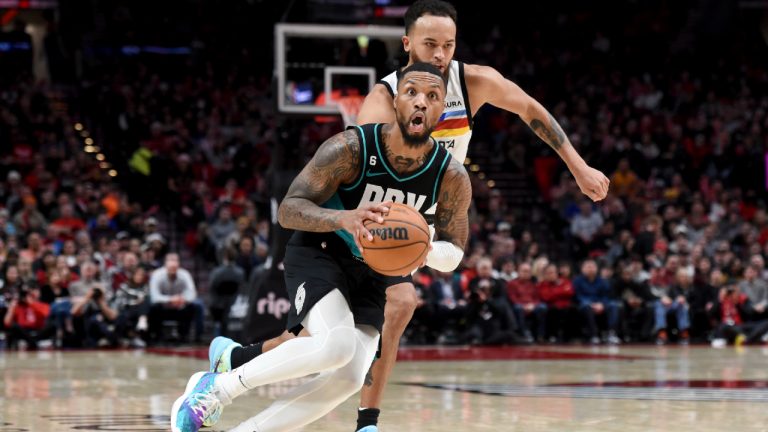 Portland Trail Blazers guard Damian Lillard, front, looks to pass the ball as Minnesota Timberwolves forward Kyle Anderson, rear, defends during the second half of an NBA basketball game in Portland, Ore., Saturday, Dec. 10, 2022. The Blazers won 124-118. (Steve Dykes/AP)