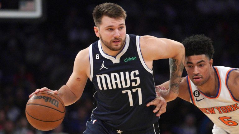 Dallas Mavericks guard Luka Doncic, left, drives the lane around New York Knicks guard Quentin Grimes, center, during the first quarter of an NBA basketball game, Saturday, Dec. 3, 2022, in New York. (Bebeto Matthews/AP)