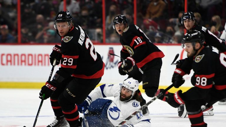 Tampa Bay Lightning left wing Pat Maroon (14) watches Ottawa Senators defenceman Dillon Heatherington (29) and defenceman Victor Mete (98) skate away with the puck after falling during first period NHL hockey action in Ottawa, on Saturday, Dec. 11, 2021. (Justin Tang/THE CANADIAN PRESS)