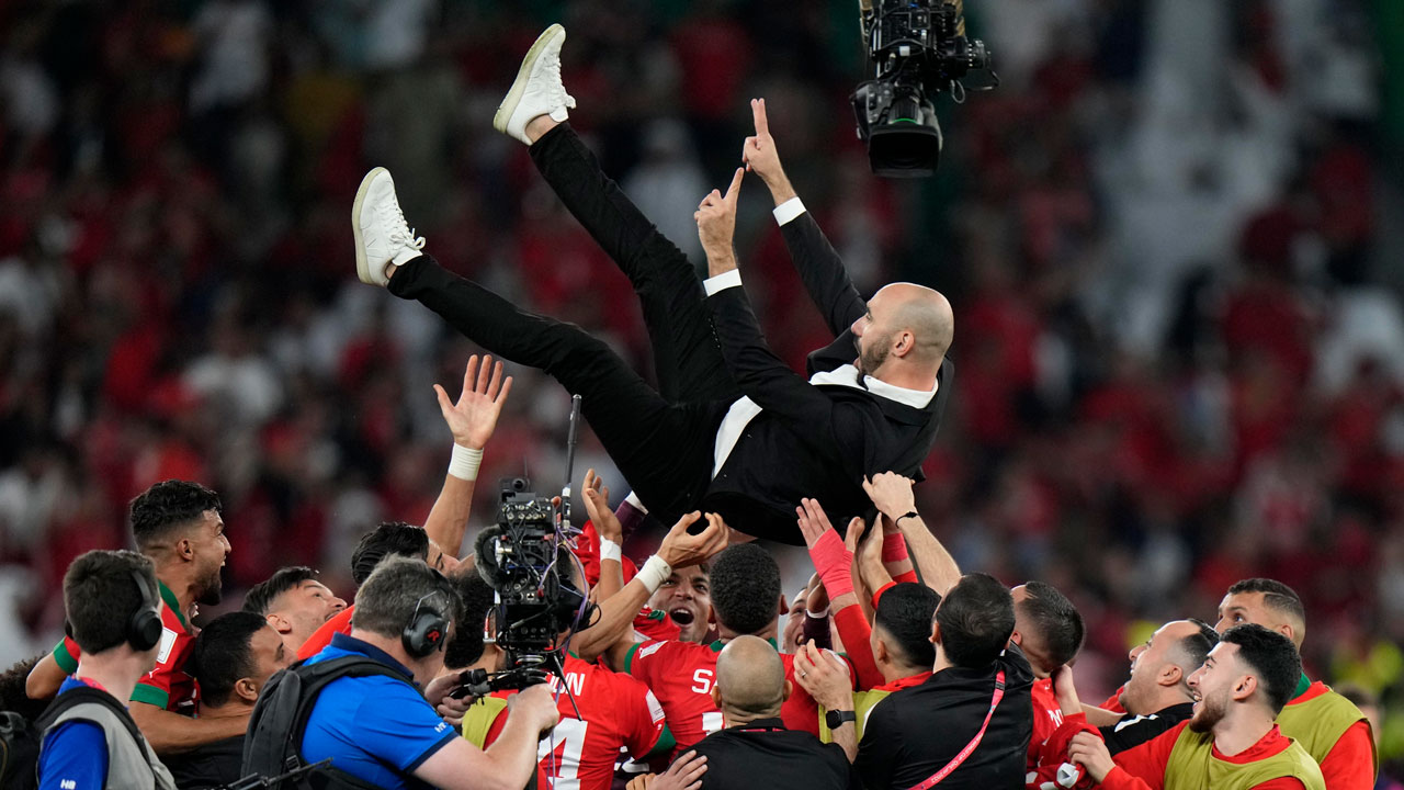 Morocco's players celebrate head coach Walid Regragui after the World Cup round of 16 soccer match between Morocco and Spain, at the Education City Stadium in Al Rayyan, Qatar. (Luca Bruno/AP)