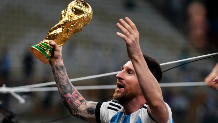 Argentina's Lionel Messi celebrates with the trophy after winning the World Cup final soccer match between Argentina and France at the Lusail Stadium in Lusail, Qatar, Sunday, Dec.18, 2022. (Manu Fernandez/AP) 