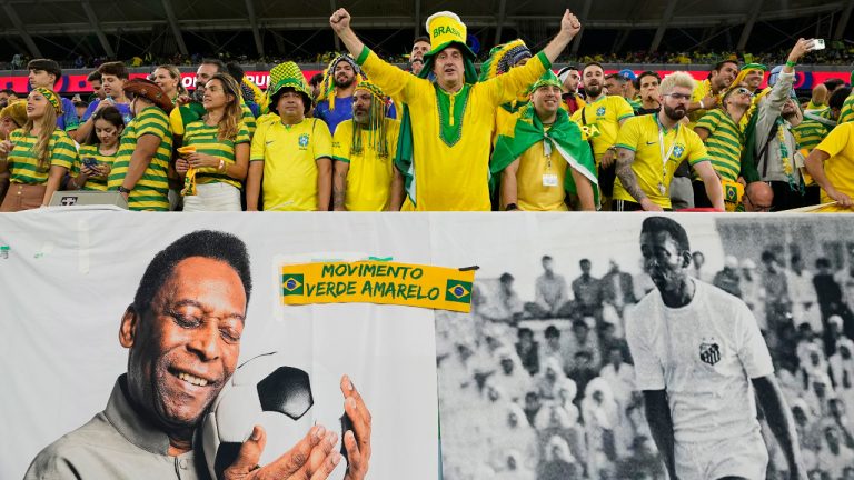 Brazil supporters cheer on the stands above a banner with pictures of soccer legend Pele, while waiting for the start of the World Cup round of 16 soccer match between Brazil and South Korea, at the Education City Stadium in Al Rayyan, Qatar, Monday, Dec. 5, 2022. (Martin Meissner/AP) 