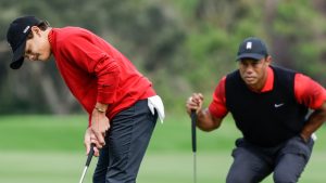 Charlie Woods, left, putts on the 2nd green while Tiger Woods, right, watches during the final round of the PNC Championship golf tournament Sunday, Dec. 18, 2022, in Orlando, Fla. (Kevin Kolczynski/AP)