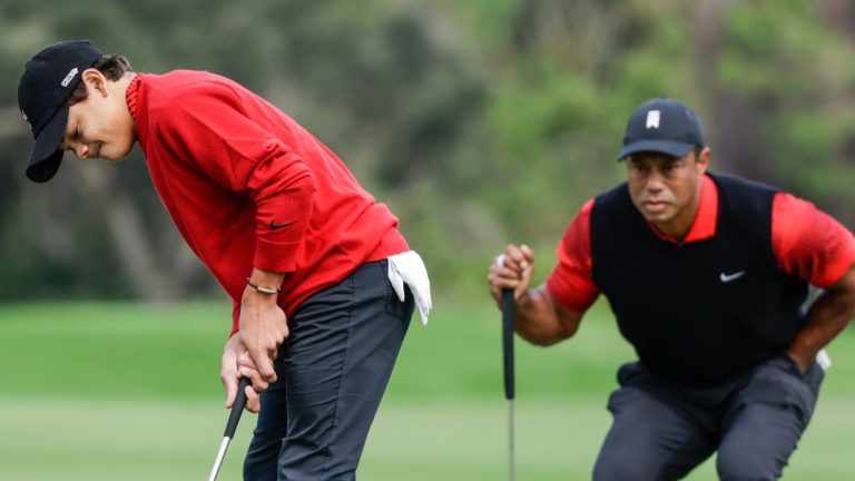 Charlie Woods, left, putts on the 2nd green while Tiger Woods, right, watches during the final round of the PNC Championship golf tournament Sunday, Dec. 18, 2022, in Orlando, Fla. (Kevin Kolczynski/AP)