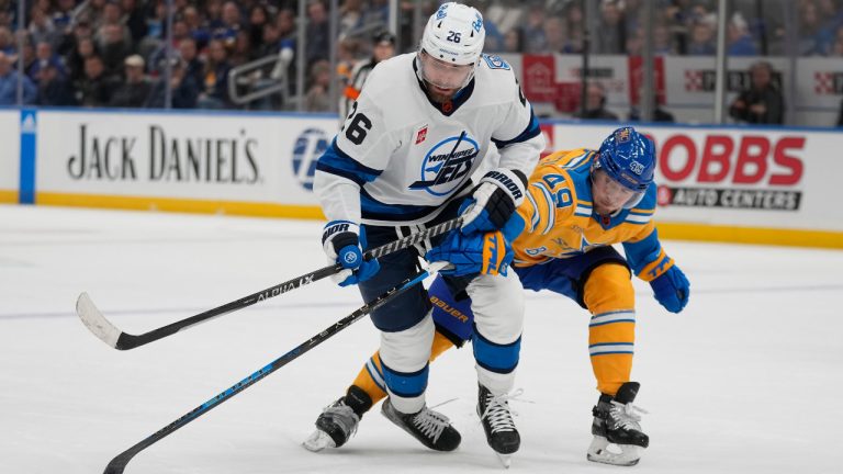 Winnipeg Jets' Blake Wheeler (26) and St. Louis Blues' Ivan Barbashev (49) chase after a loose puck during the first period of an NHL hockey game Thursday, Dec. 8, 2022, in St. Louis. (Jeff Roberson/AP) 