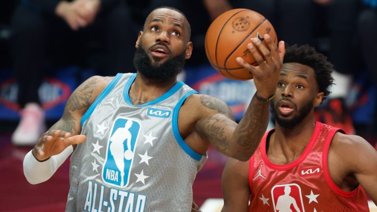 Los Angeles Lakers' LeBron James, left, puts up a shot in front of Golden State Warriors' Andrew Wiggins during the first half of the NBA All-Star basketball game, Sunday, Feb. 20, 2022, in Cleveland. (Ron Schwane/AP Photo)