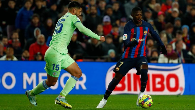 Barcelona's Ousmane Dembele, right, runs with the ball past Getafe's Omar Alderete during a Spanish La Liga soccer match between Barcelona and Getafe at the Camp Nou stadium in Barcelona, Spain, Sunday, Jan. 22, 2023. (Joan Monfort/AP)