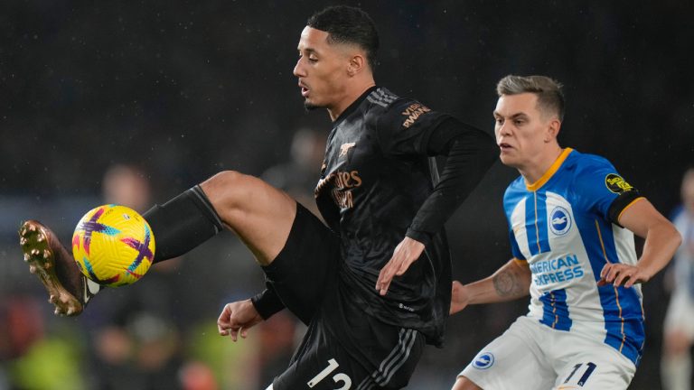 Arsenal's William Saliba, left, vies for the ball with Brighton's Leandro Trossard during the English Premier League soccer match between Brighton and Hove Albion and Arsenal and at the AMEX Community Stadium in Brighton, England, Saturday, Dec. 31, 2022. (Alastair Grant/AP)