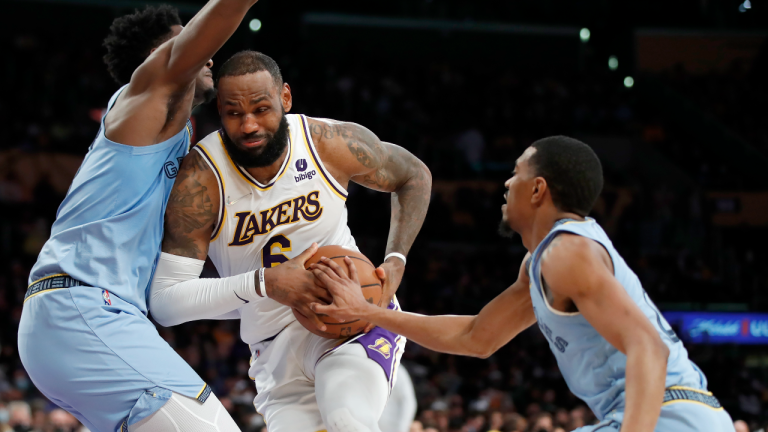 Los Angeles Lakers forward LeBron James, centre, collides with Memphis Grizzlies forward Jaren Jackson Jr., left, as guard De'Anthony Melton, right, reaches for the ball during the second half of an NBA basketball game, Sunday, Jan. 9, 2022, in Los Angeles. (AP)