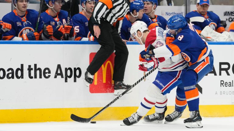 Montreal Canadiens right wing Evgenii Dadonov (63) and New York Islanders defenseman Noah Dobson (8) fights for the puck during the first period of an NHL hockey game, Saturday, Jan. 14, 2023, in Elmont, N.Y. (Mary Altaffer/AP)