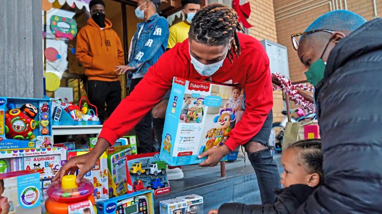 Damar Hamlin, center, helps pick out a toy for Rhyell Chapple, 1, of McKees Rocks, Pa., during Hamlin's Chasing M's Foundation community toy drive at Kelly and Nina's Daycare Center, Tuesday, Dec. 22, 2020, in McKees Rocks, Pa. (Matt Freed/Pittsburgh Post-Gazette via AP)