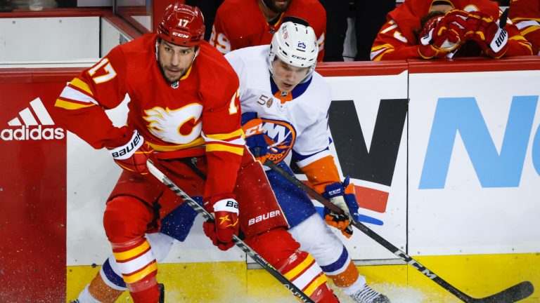 New York Islanders defenceman Sebastian Aho, right, is checked by Calgary Flames forward Milan Lucic during first period NHL hockey action in Calgary, Friday, Jan. 6, 2023. (Jeff McIntosh/CP)