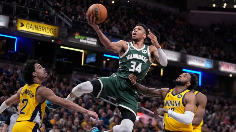 Milwaukee Bucks' Giannis Antetokounmpo (34) puts up a shot against Indiana Pacers' Andrew Nembhard (2) and Oshae Brissett (12) during the second half of an NBA basketball game, Friday, Jan. 27, 2023, in Indianapolis. (Darron Cummings/AP)