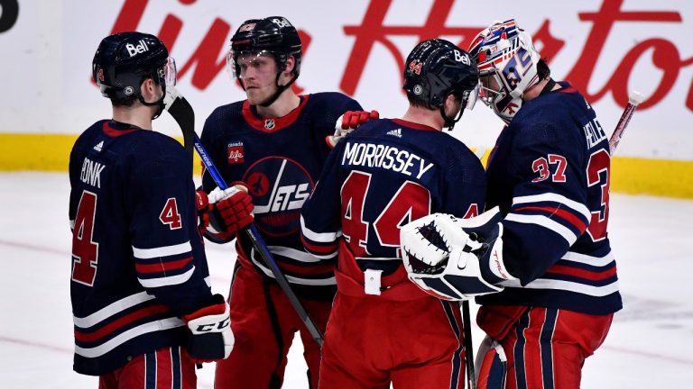 Winnipeg Jets' Josh Morrissey (44) celebrates with goaltender Connor Hellebuyck (37) after beating the St. Louis Blues during NHL action in Winnipeg on Monday January 30, 2023. (Fred Greenslade/CP)