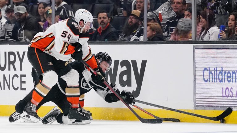 Los Angeles Kings center Jaret Anderson-Dolan, right, falls as he and Anaheim Ducks center Justin Kirkland reach for the puck during the third period of a preseason NHL hockey game Sunday, Oct. 2, 2022, in Los Angeles. (Mark J. Terrill/CP)